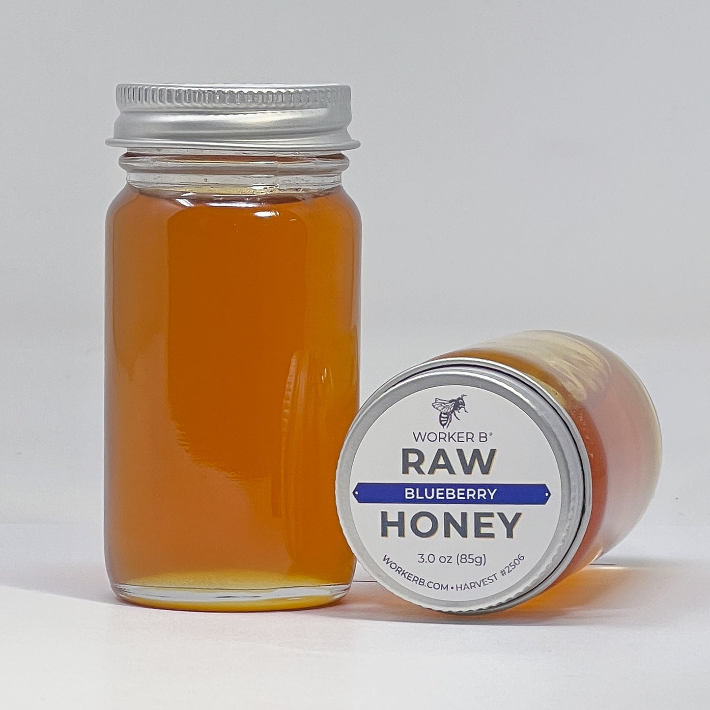 Jar of raw blueberry honey with a label on a white background