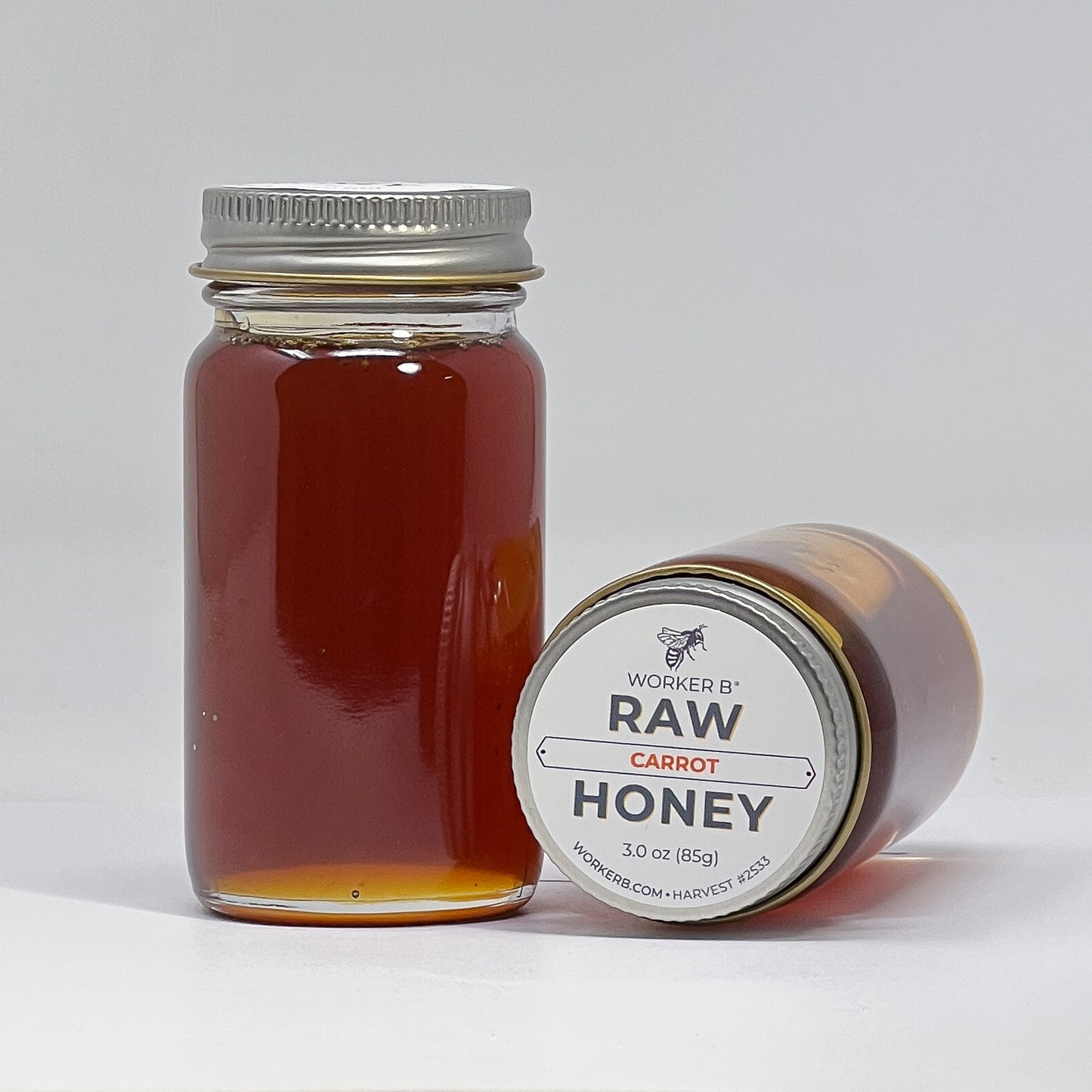 Jar of raw carrot honey with a label on a white background