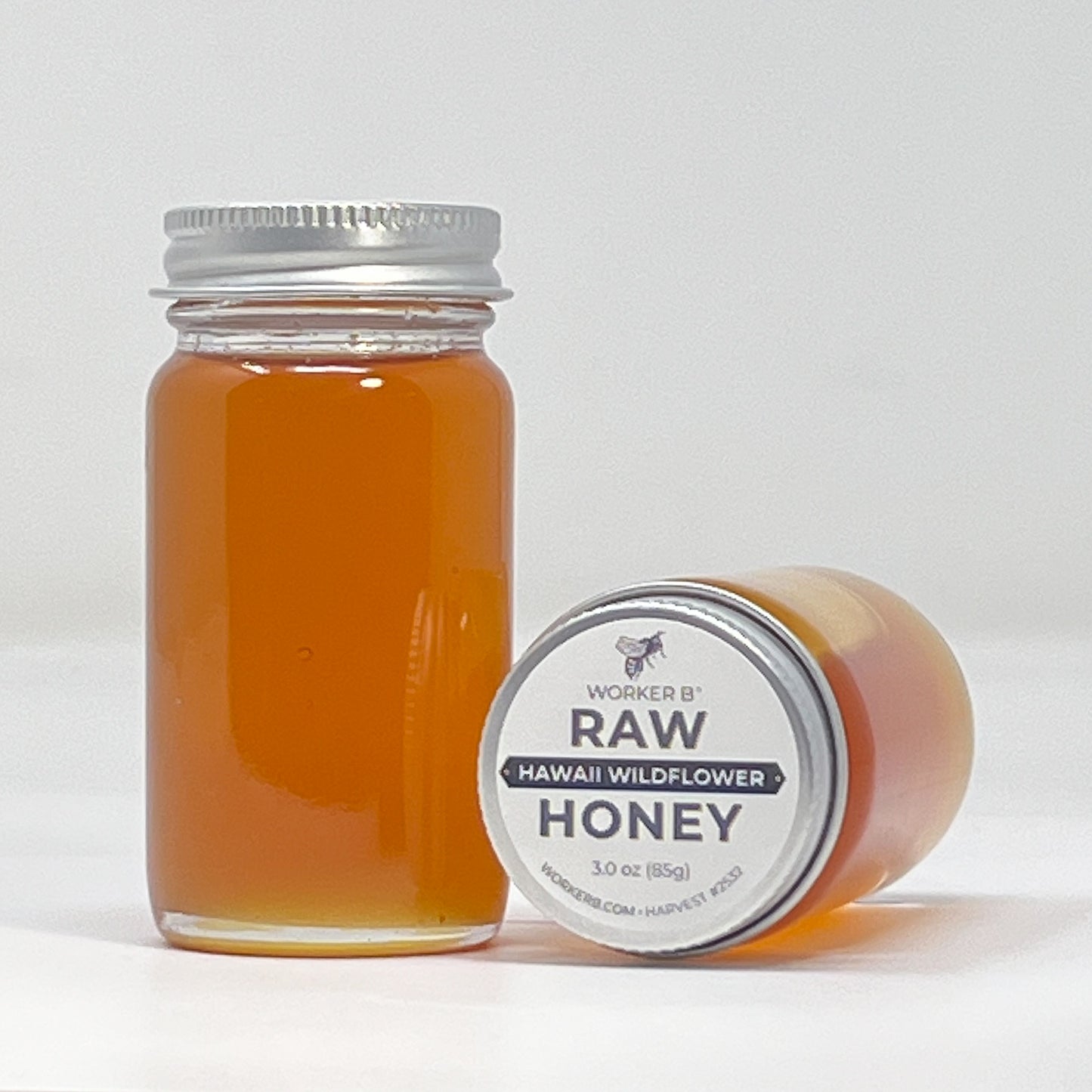 Jar of raw honey with a label on a white background