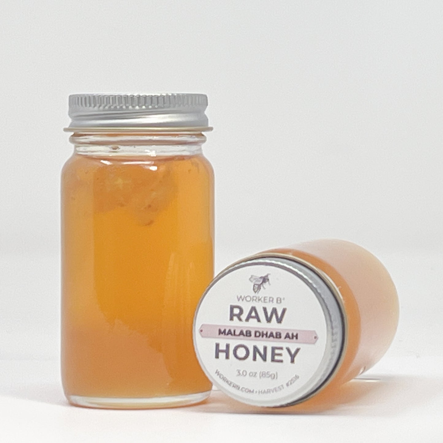 Jar of raw honey with a label on a white background