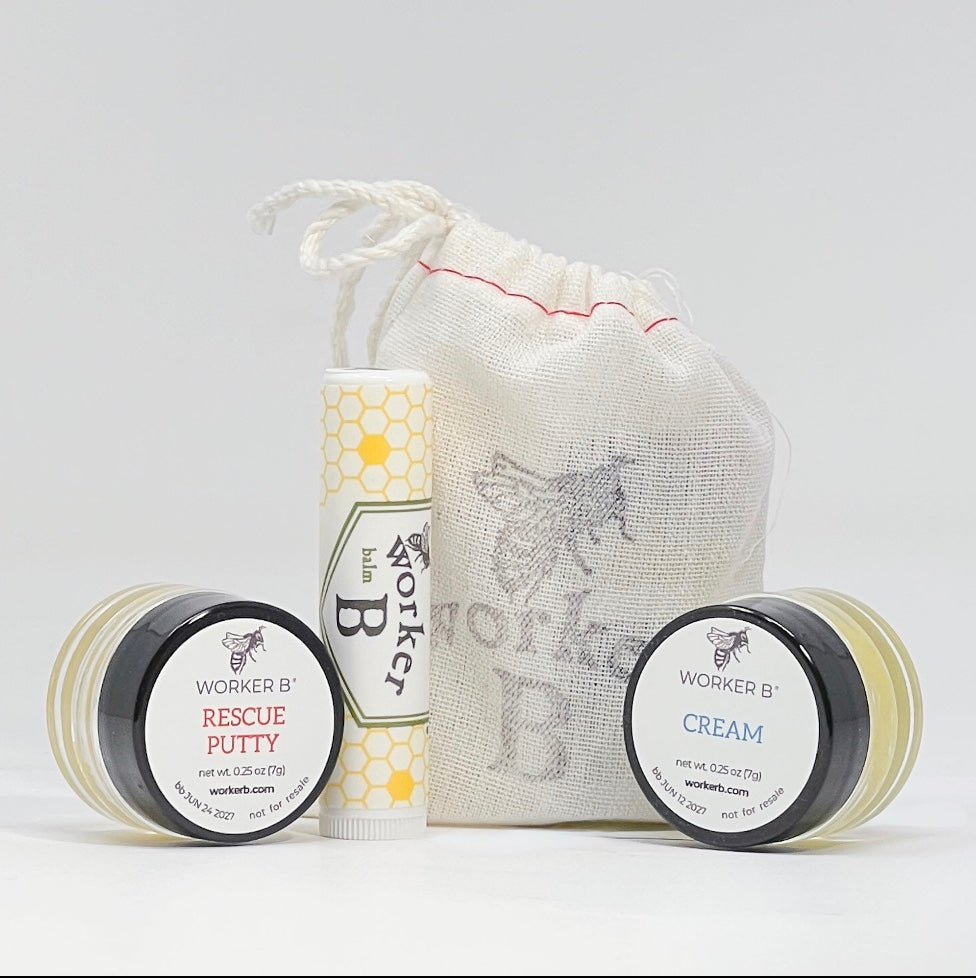 Worker B skincare products including a jar, tube, and cream with a drawstring bag on a light gray background.