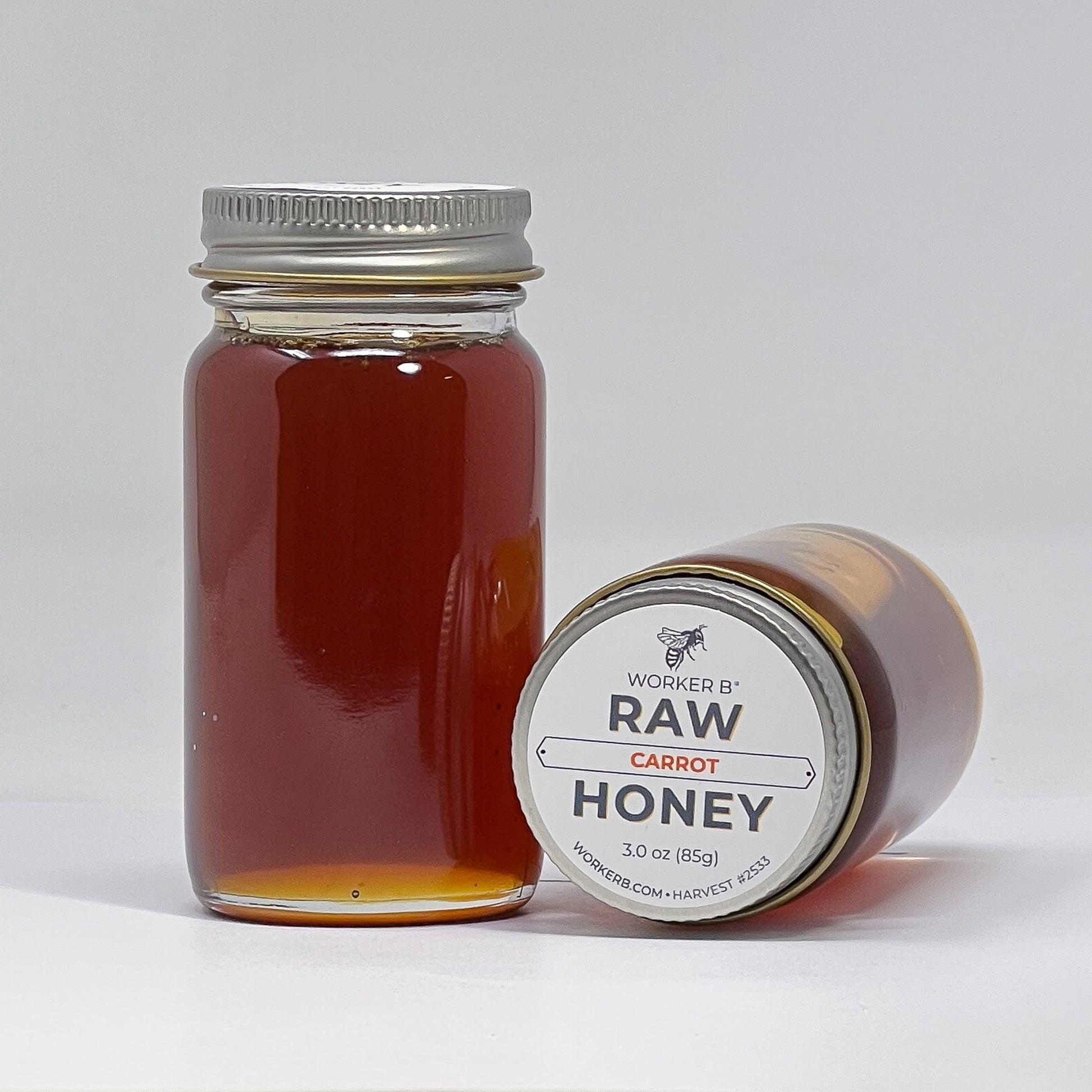 Jar of raw carrot honey with a label on a white background