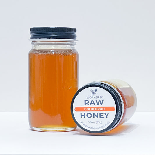 Jar of raw honey with a label on a white background