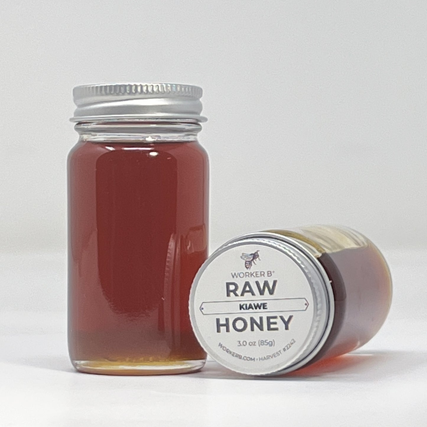 Jar of raw honey with a label on a white background