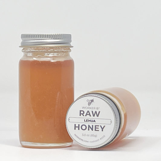 Jar of raw honey with a label on a white background