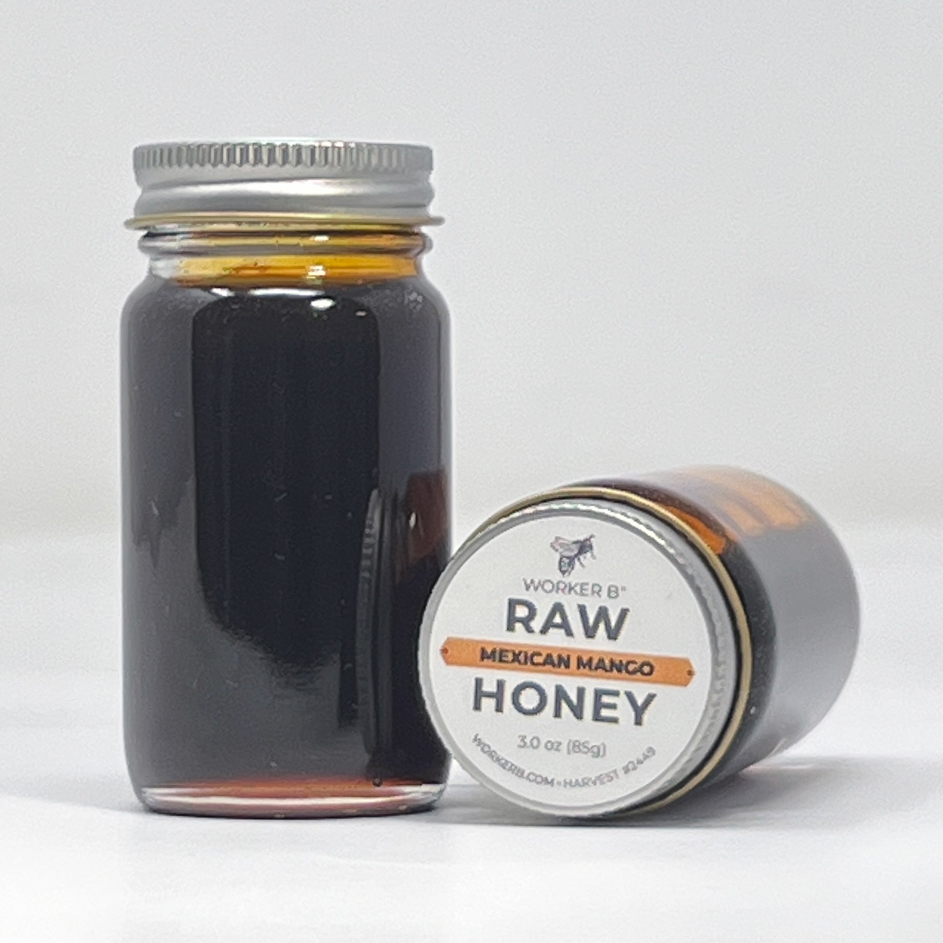Jar of raw Mexican mango honey with a label on a white background