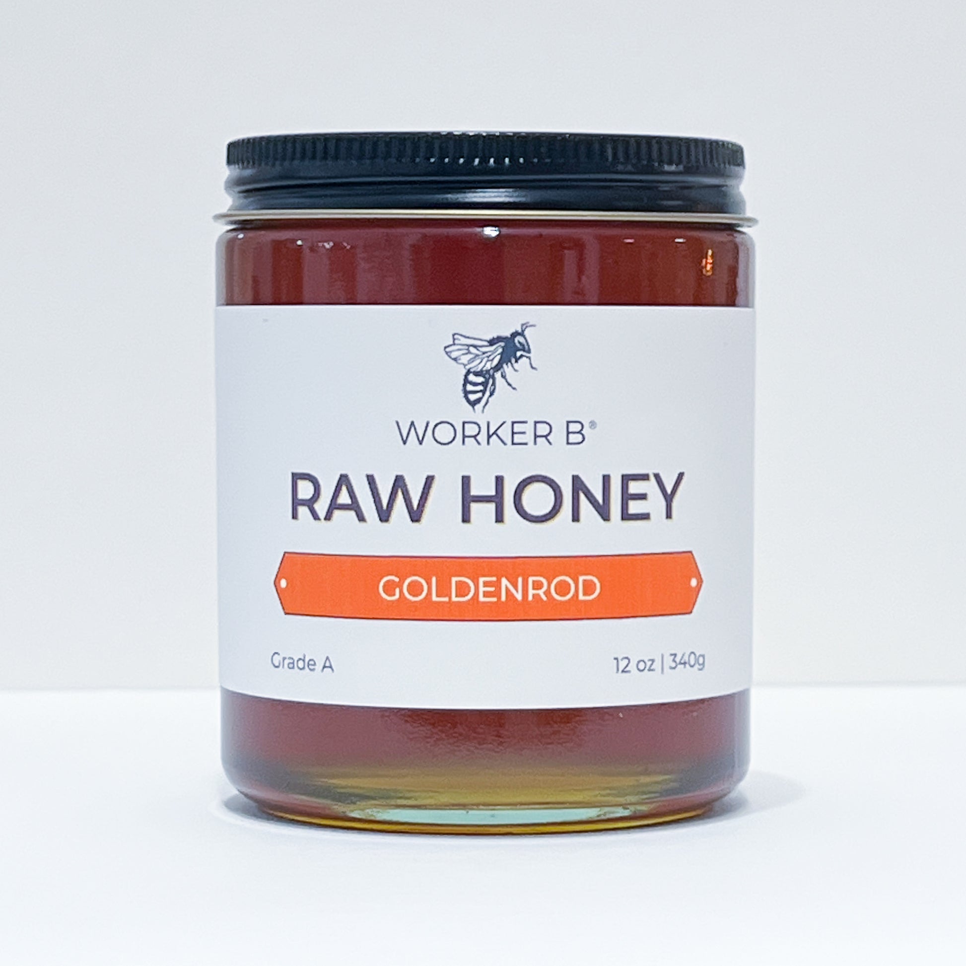 Jar of Worker B Raw Honey with a white label on a light gray background