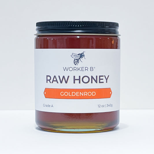 Jar of Worker B Raw Honey with a white label on a light gray background