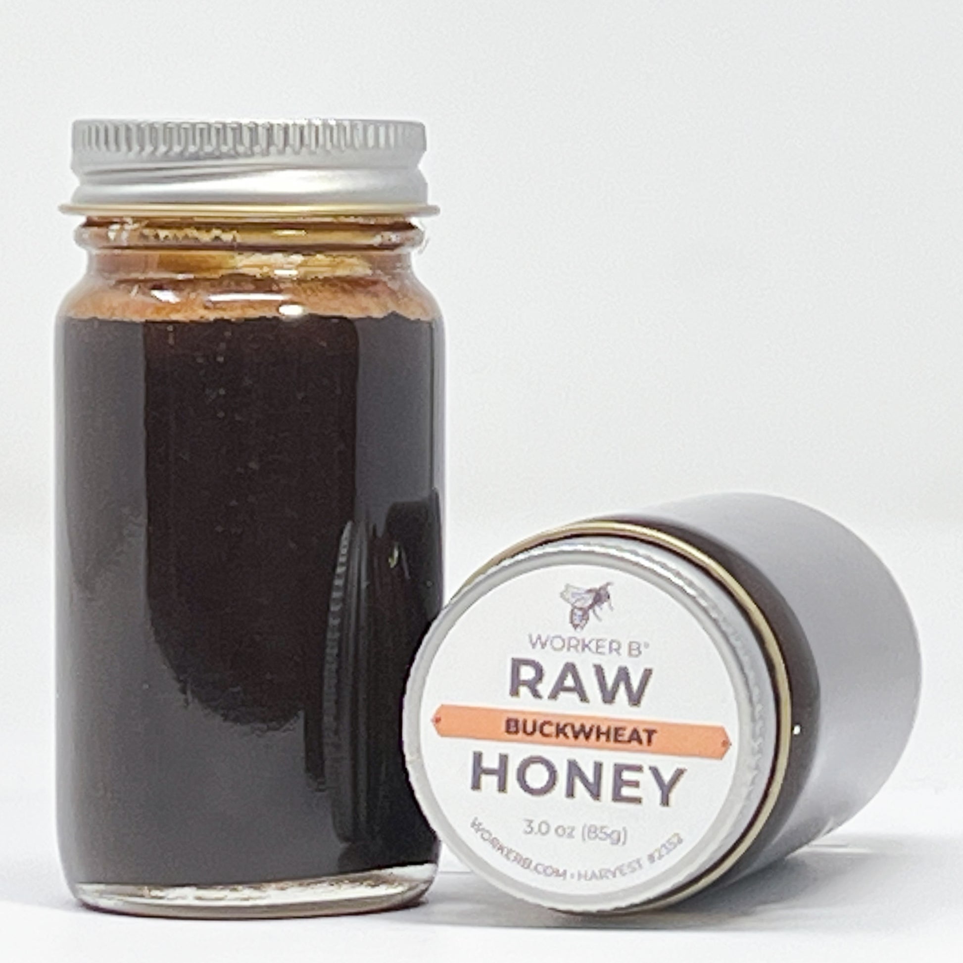 Jar of raw buckwheat honey with a label on a white background